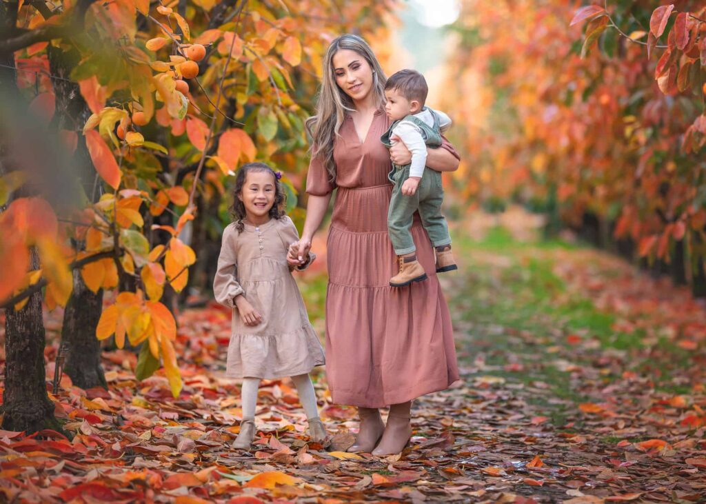 Mum holding her 2 kids during autumn family session in Melbourne