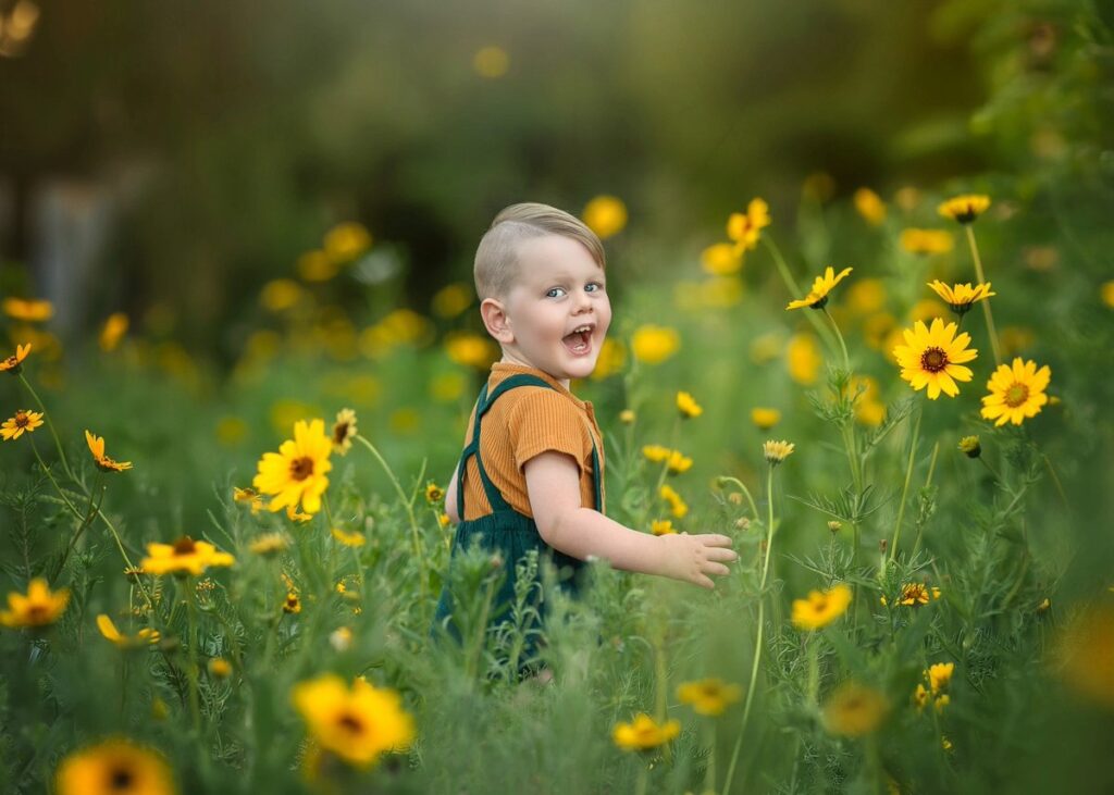 Smiling young boy among yellow wildflowers, Perth children's portraits in Swan Valley